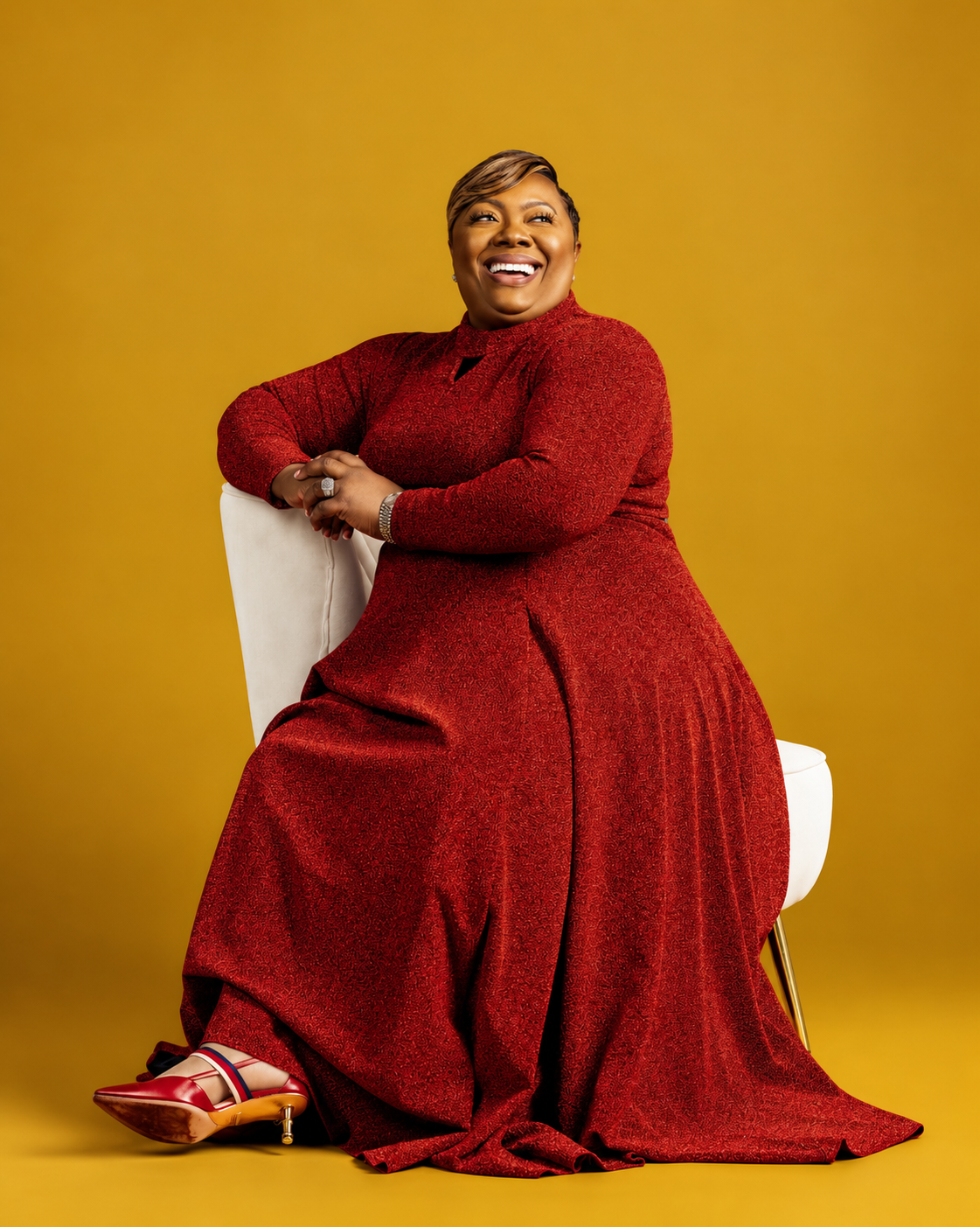 Prophetess Dr. Mattie Nottage seated in a red dress against a gold background
